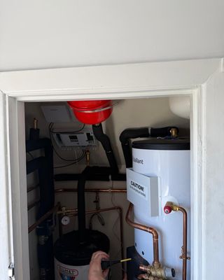 Vaillant cylinder and expansion vessel being commissioned in an airing cupboard.